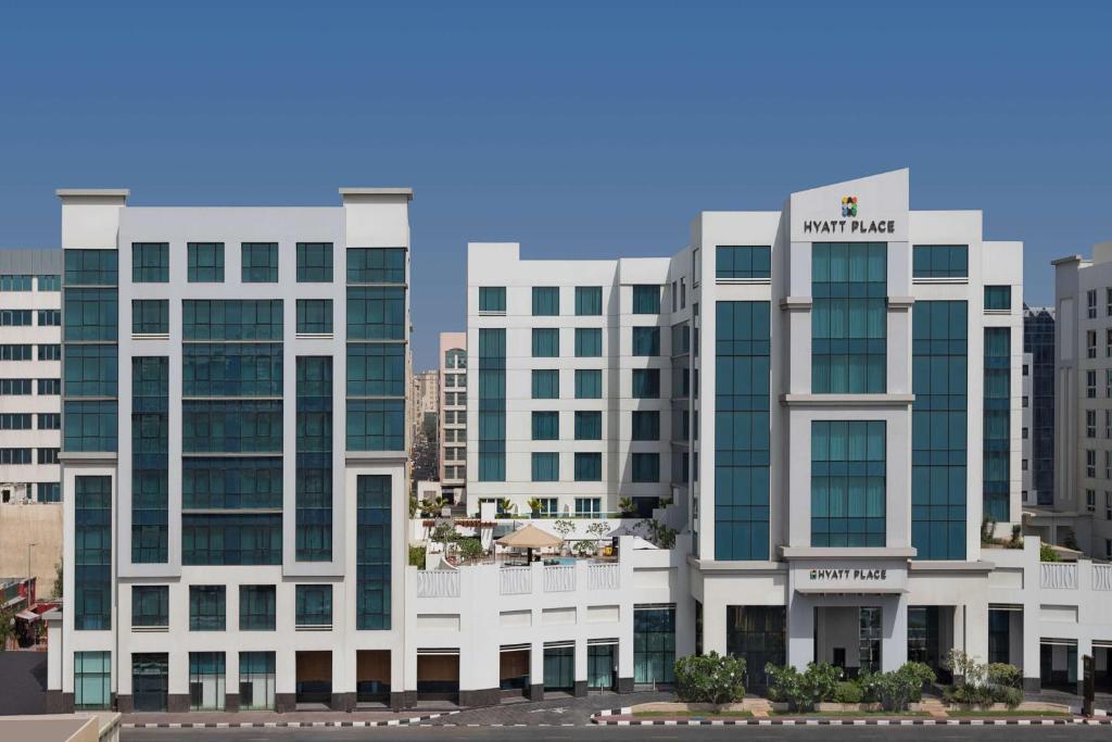 a large white building with a sign on it at Hyatt Place Dubai Al Rigga in Dubai