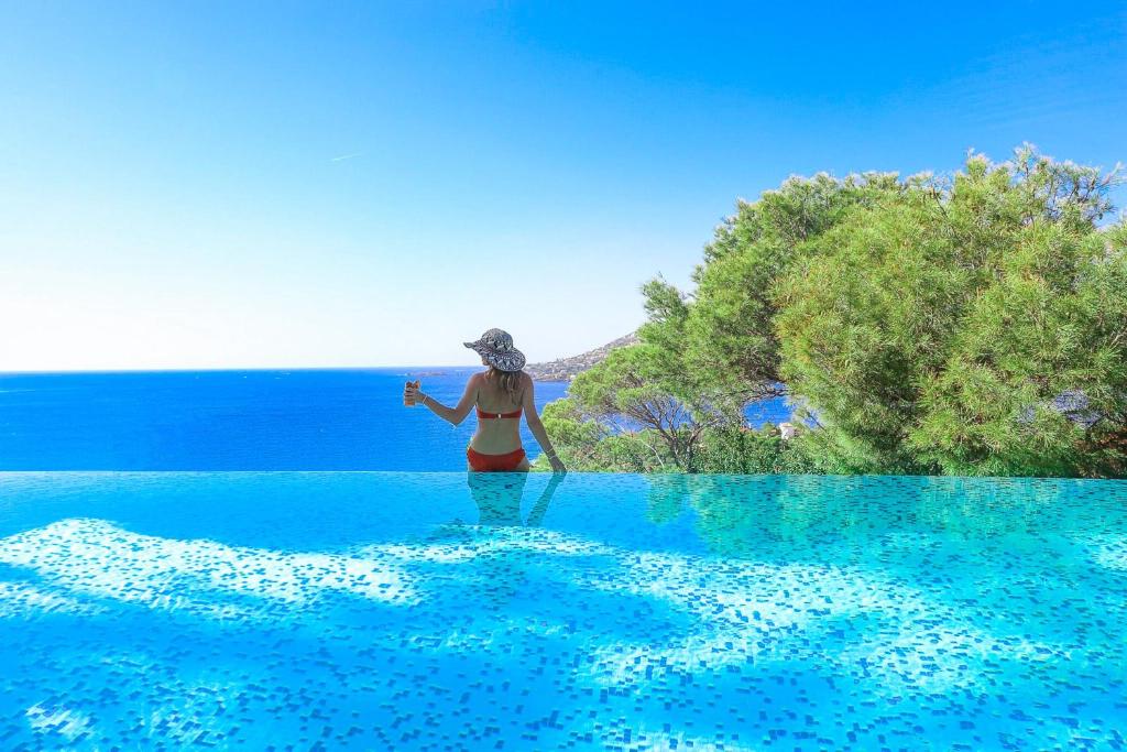 a woman in a bikini standing in the middle of the ocean at La Farigoule in Saint-Raphaël