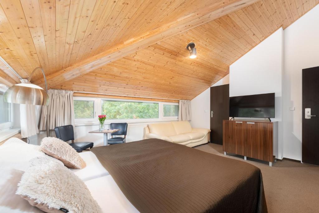 1 dormitorio con 1 cama grande y techo de madera en Hotel U Šuláka, en Brno
