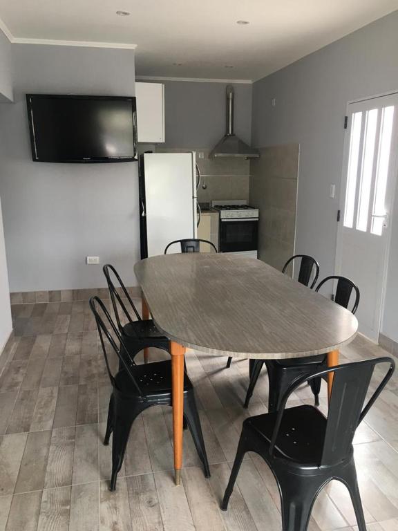 una mesa y sillas en una habitación con cocina en La Casa de Monte en Monte Hermoso