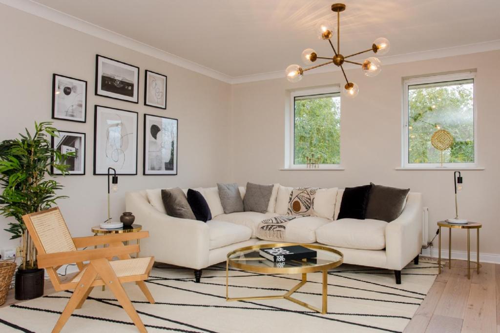 ein Wohnzimmer mit 2 weißen Sofas und einem Tisch in der Unterkunft The Sparkford Gardens - Lovely 2BDR with Balcony in London