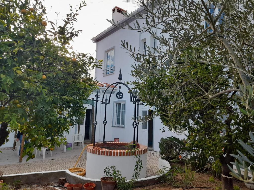 une maison blanche avec des arbres devant elle dans l'établissement Pias Guesthouse, à Pias