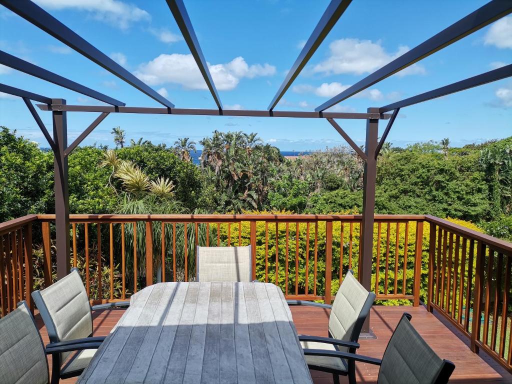 a wooden deck with a table and chairs on it at Ridgeview Holiday Accommodation in Umzumbe