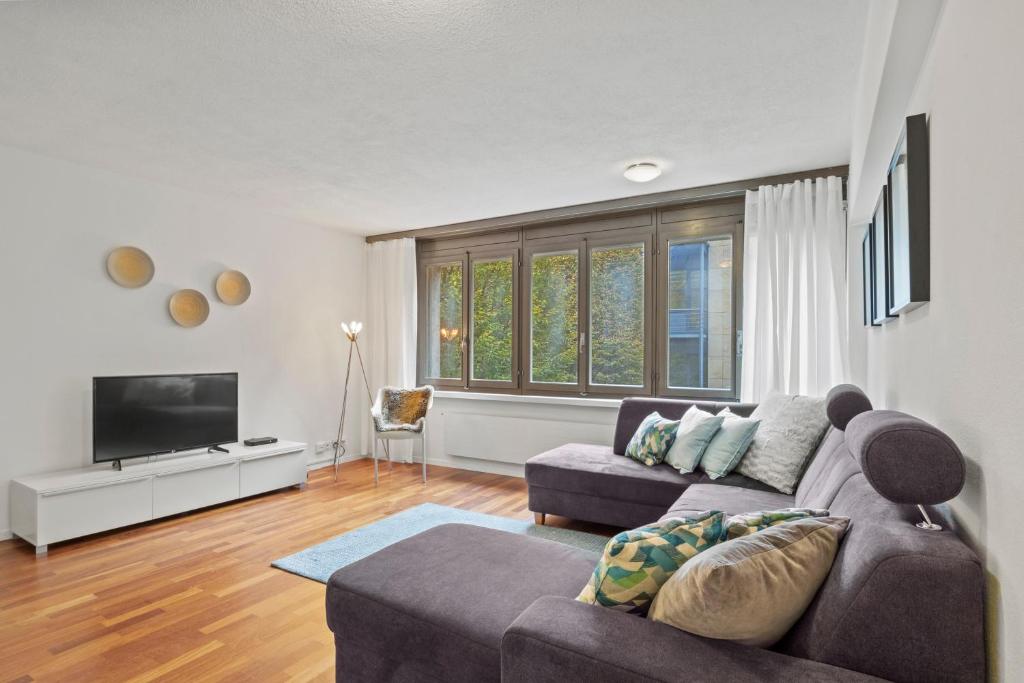 a living room with a couch and a tv at Large, central, bright flat in Luzern