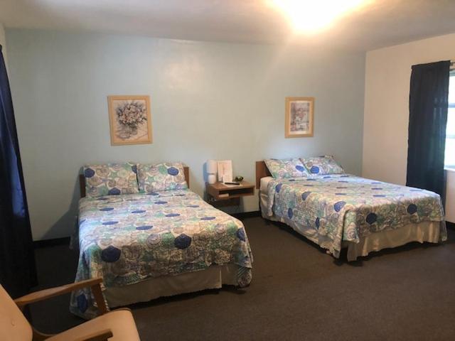 - une chambre avec 2 lits et une table avec une chaise dans l'établissement Cindy’s Motel & RV Park, à Mayo
