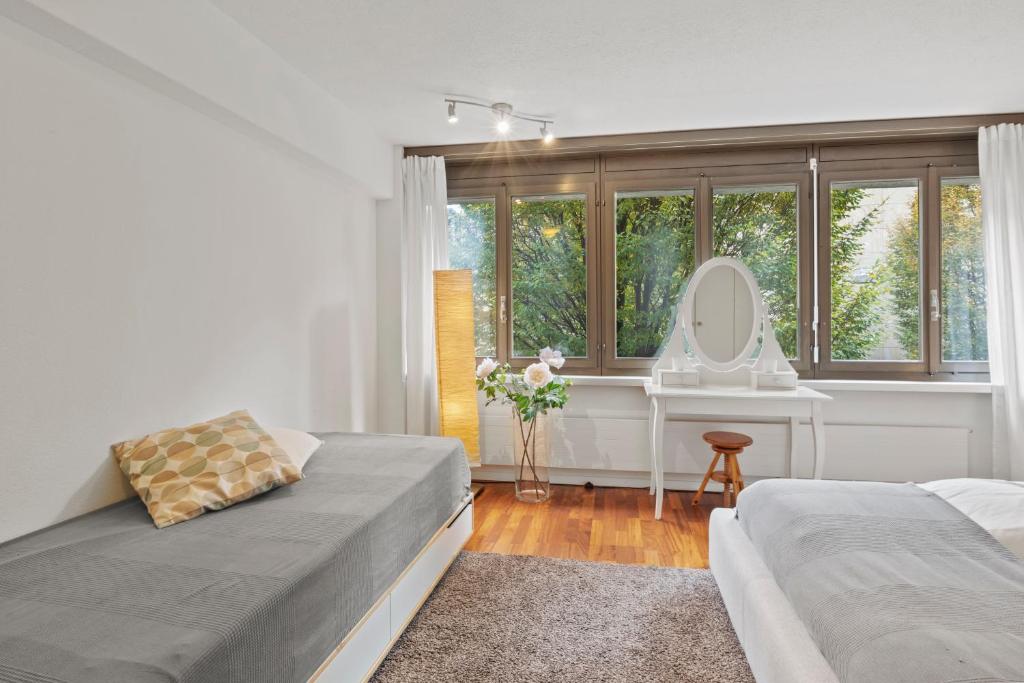 a bedroom with two beds and a sink and a mirror at Large, central, bright flat in Luzern