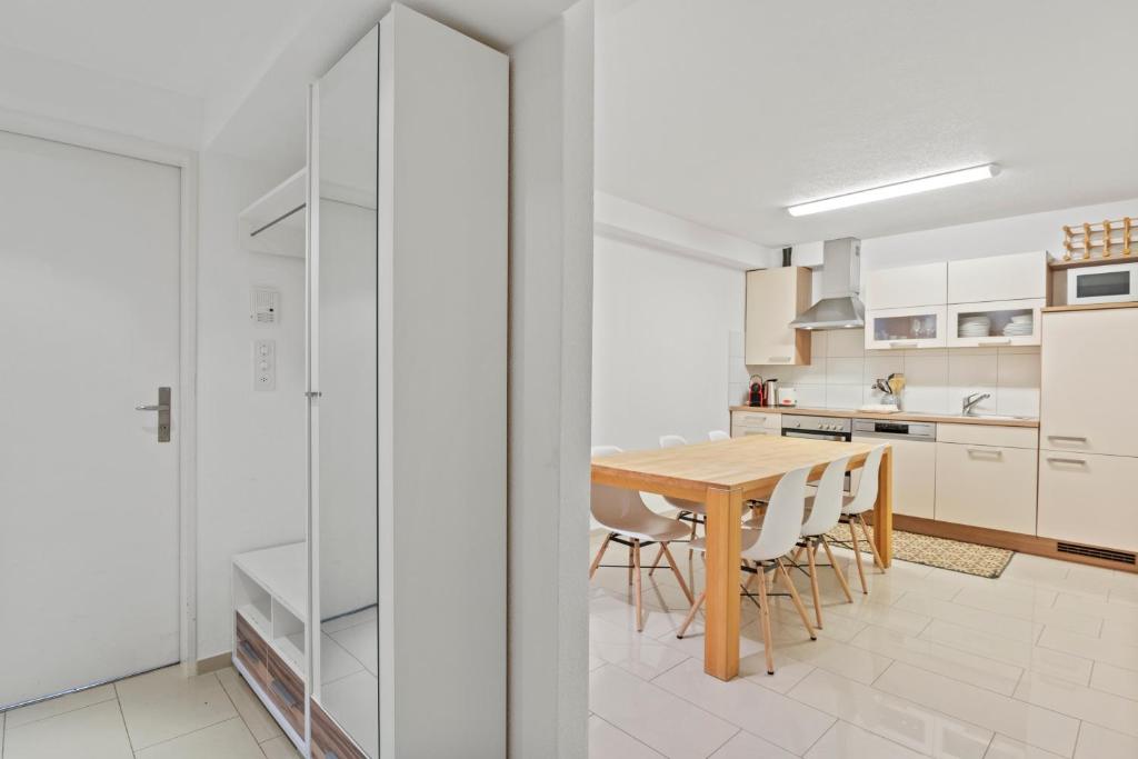 a kitchen and dining room with a wooden table and chairs at Large, central, bright flat in Luzern