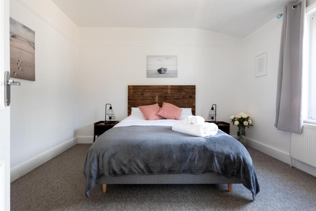 een slaapkamer met een groot bed met roze kussens bij Little Haven in Falmouth