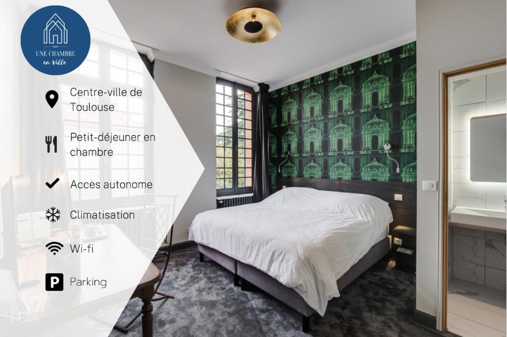 a bedroom with a bed and a green wall at Hôtel Une Chambre en Ville in Toulouse