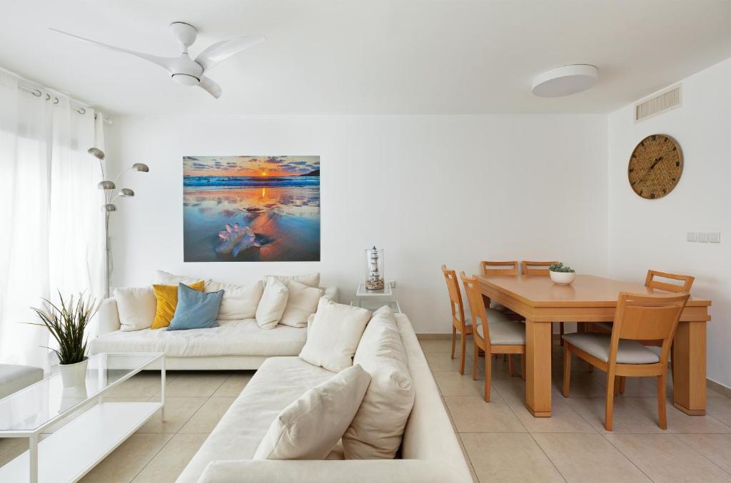 sala de estar con sofá blanco y mesa en A white dream by the sea - 2bd lux family apartment en Herzliyya B