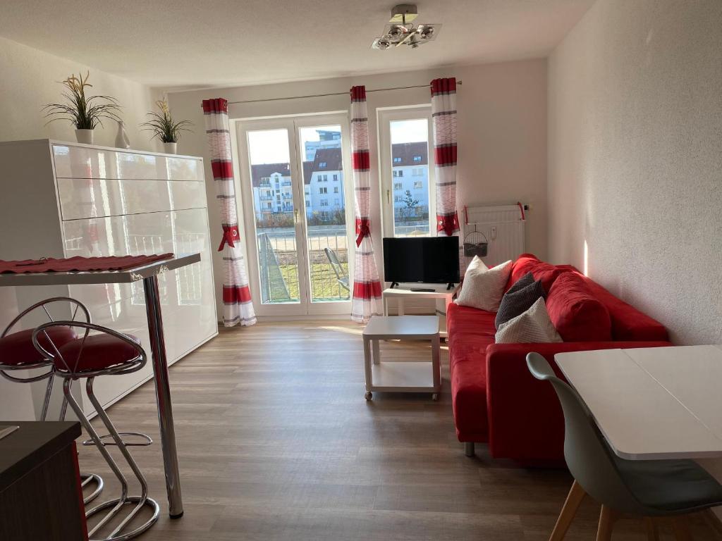 a living room with a red couch and a table at Apartment- Singen Überlinger Straße in Singen