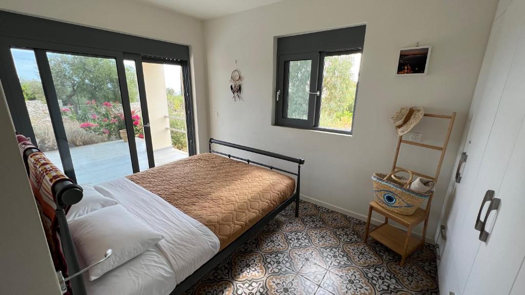 a bedroom with a bed and two windows at Luxurious villa at a unique spot in Agios Nikolaos
