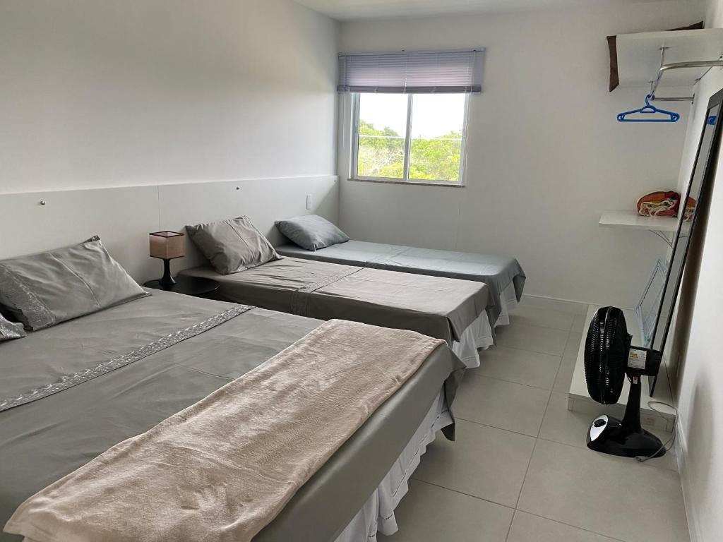 a hospital room with two beds and a window at Arraial do Cabo-Apartamento para temporada-Condomínio Golden Lake in Arraial do Cabo