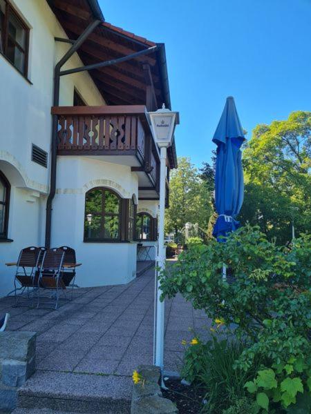 a building with a balcony and an umbrella and a table at Kleines Brauhaus Ingolstadt in Ingolstadt