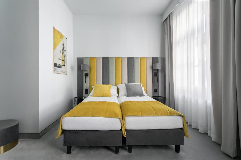 a bedroom with a bed with a yellow blanket at Old Town Residence - Premium Aparthotel in Krakow
