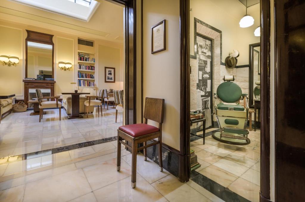 A view into the book-lined lounge beside a vintage barber-themed display room.