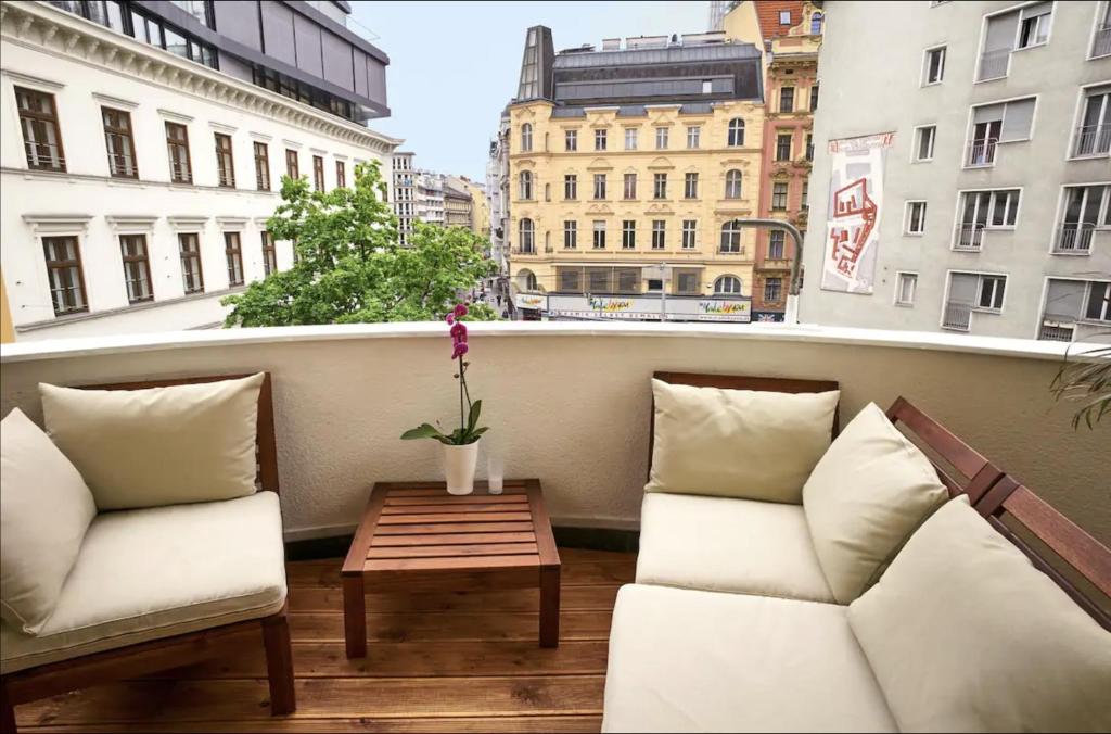 een balkon met twee banken en een salontafel in een gebouw bij Balcony Oasis Operastreet in Wenen