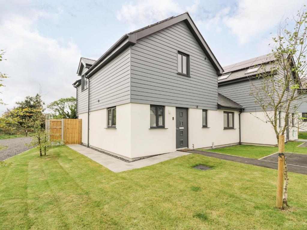 a home with a grey and white house with a yard at 20 Parc Delfryn in Brynteg