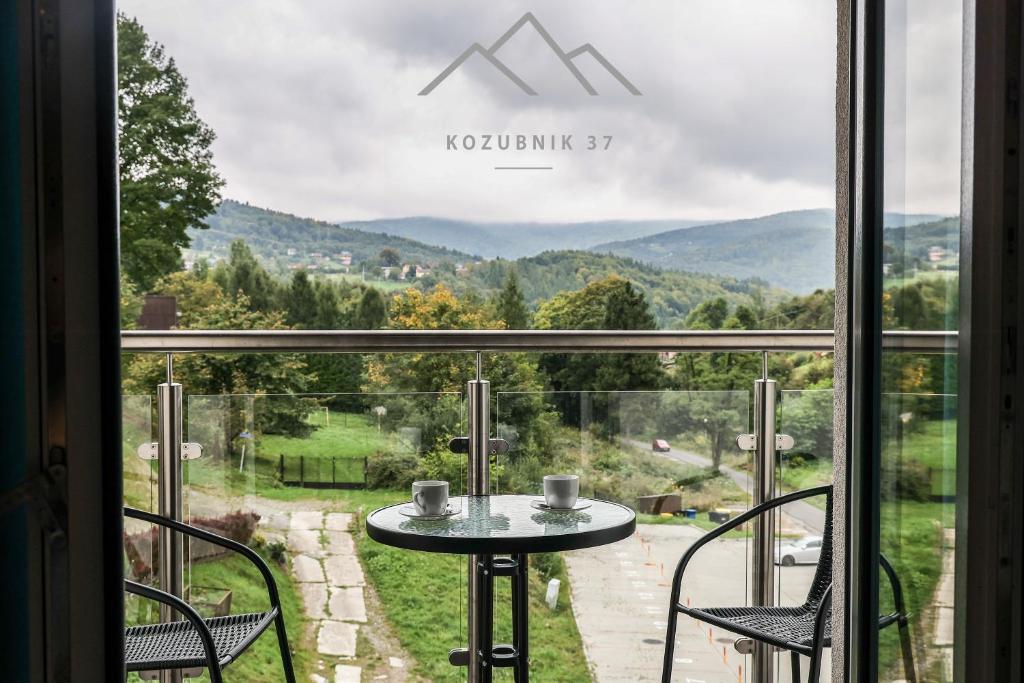 a view from the balcony of a house with a table and chairs at Kozubnik 37 in Porąbka