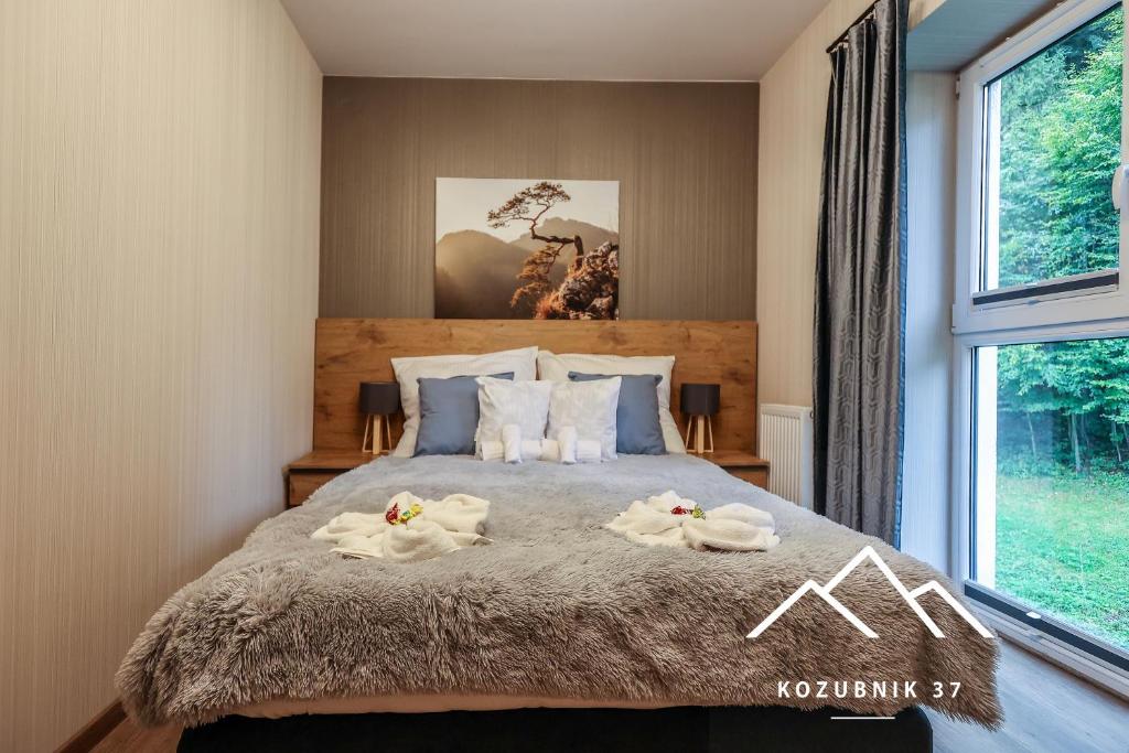 sypialnia z łóżkiem i ręcznikami w obiekcie Kozubnik 37 w mieście Porąbka