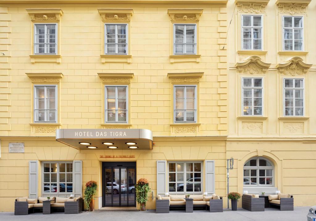 un edificio giallo con un cartello che legge Hotel des Lion di Boutique Hotel Das Tigra a Vienna