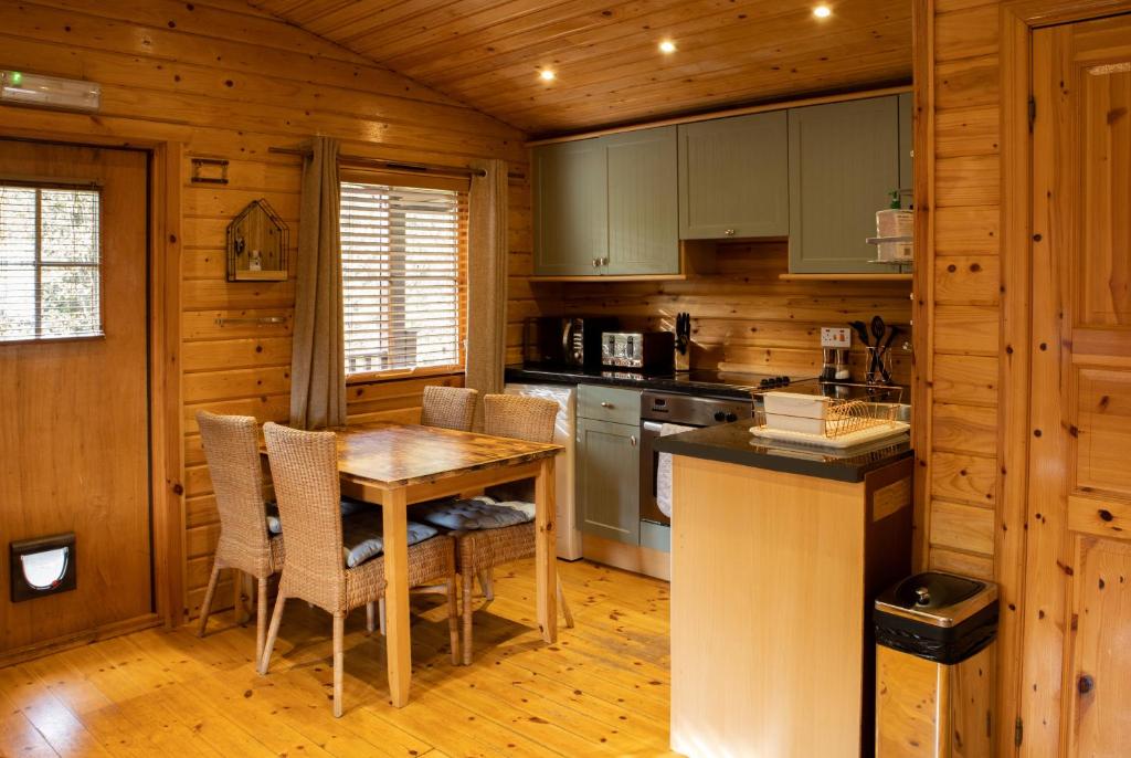 una cucina con tavolo e sedie in una cabina di The Steadings Log Cabins a Kettlebridge