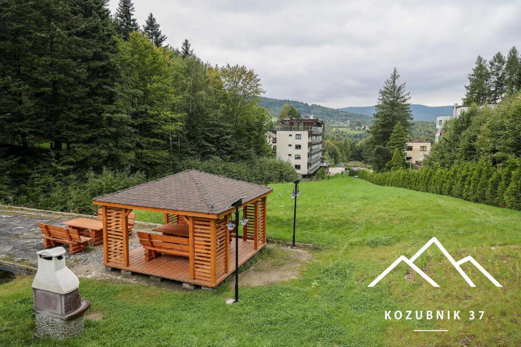 drewniany domek na polu zielonej trawy w obiekcie Kozubnik 37 w mieście Porąbka