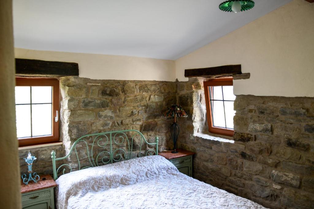 阿普里卡萊的住宿－CASA LUCERTOLA，一间卧室设有一张床和石墙