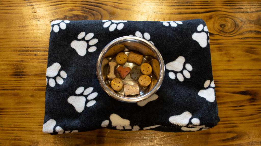 una ciotola di cibo per cani su un tovagliolo con le impronte delle zampe di The Steadings Log Cabins a Kettlebridge