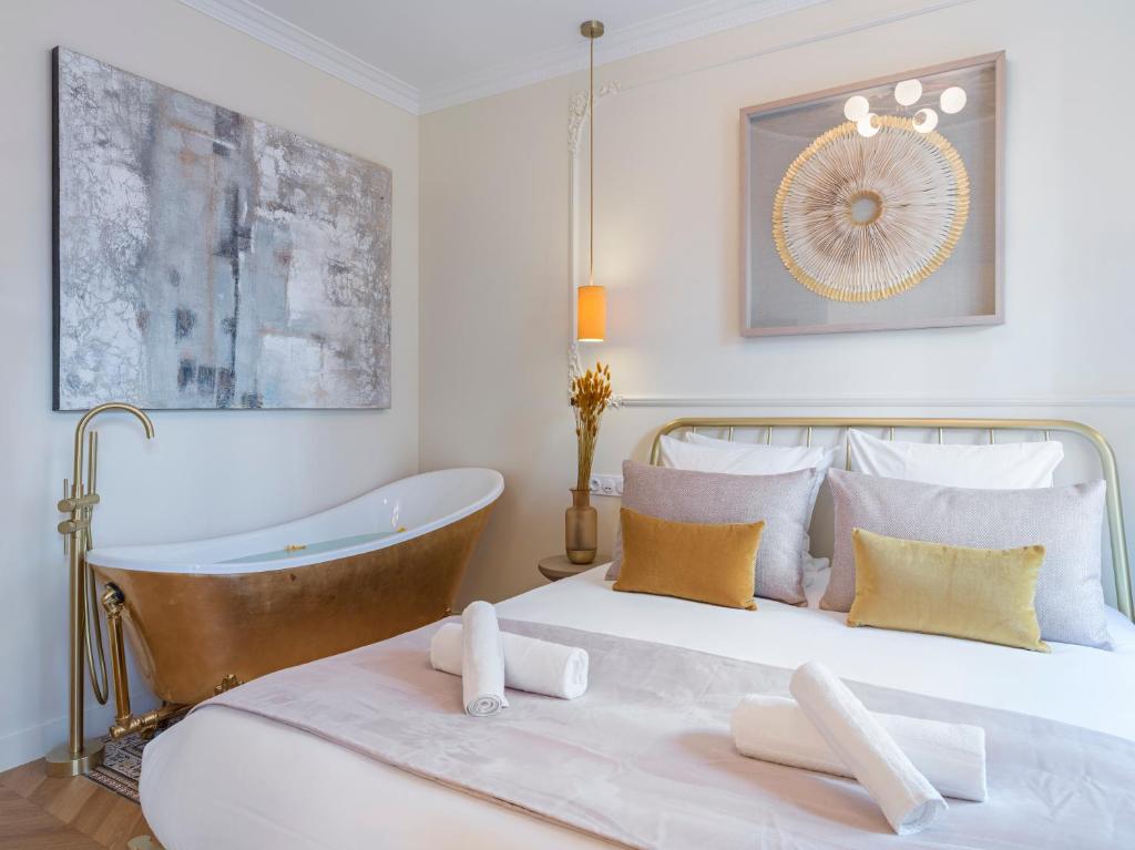 une chambre avec un lit et une baignoire dans l'établissement The Gatsby Suite, à Paris