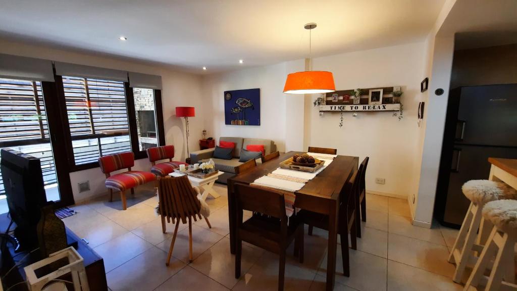 uma sala de estar com uma mesa e uma sala de jantar em Departamento cálido y cómodo muy bien ubicado 4pax em San Martín de los Andes