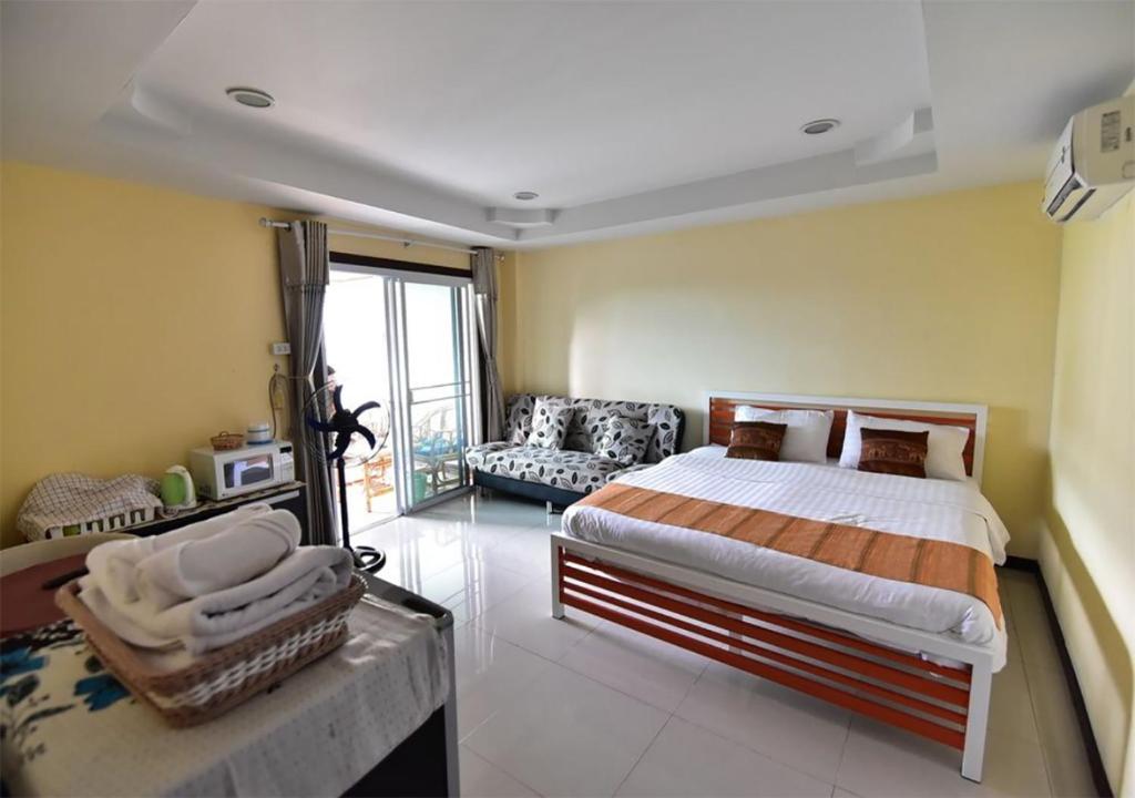 a bedroom with a bed and a couch in it at Joy House Jomtien Beach in Jomtien Beach