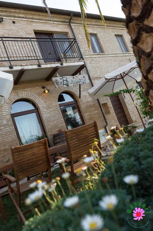 zwei Holzbänke vor einem Gebäude in der Unterkunft Bassarì in Recanati