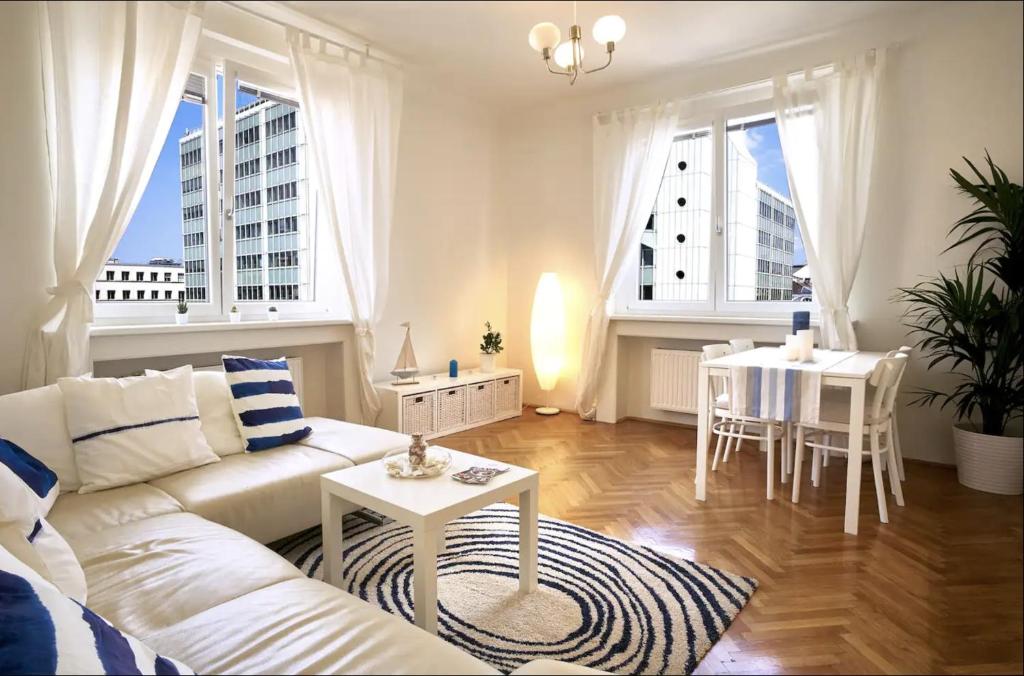 a living room with a white couch and a table at Operastreet City Center Santorin in Vienna