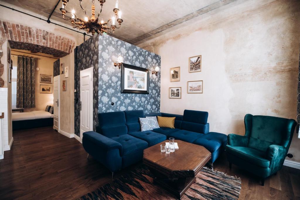 un soggiorno con divano blu e sedie di Native Apartments Dunajewskiego 2 a Cracovia