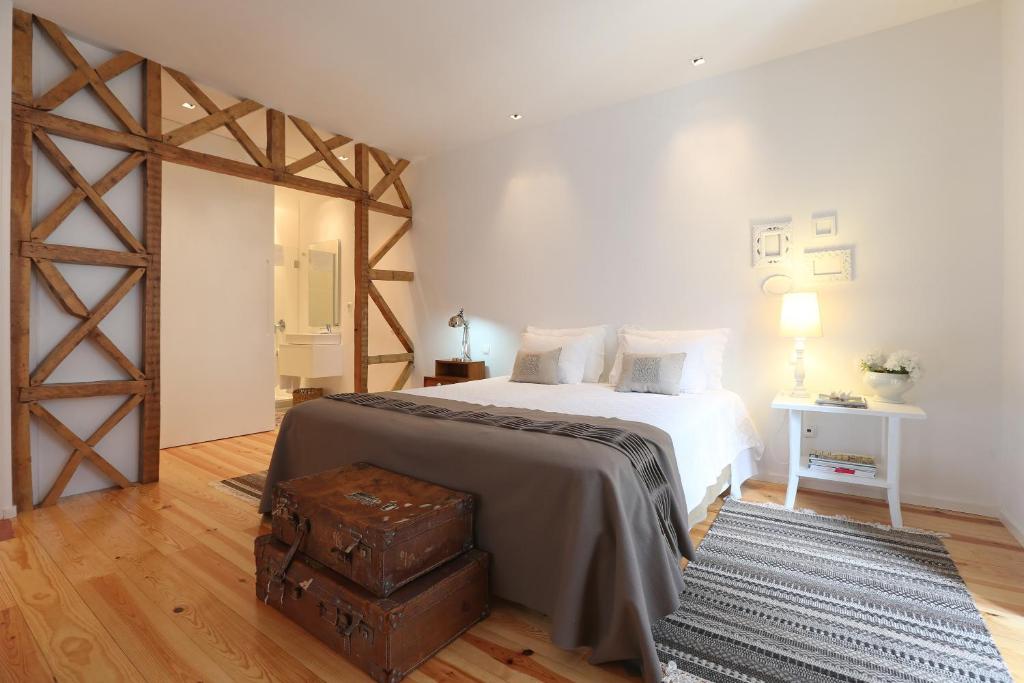 een slaapkamer met een groot bed en een bruine koffer bij My Lisbon Apartment in Lissabon