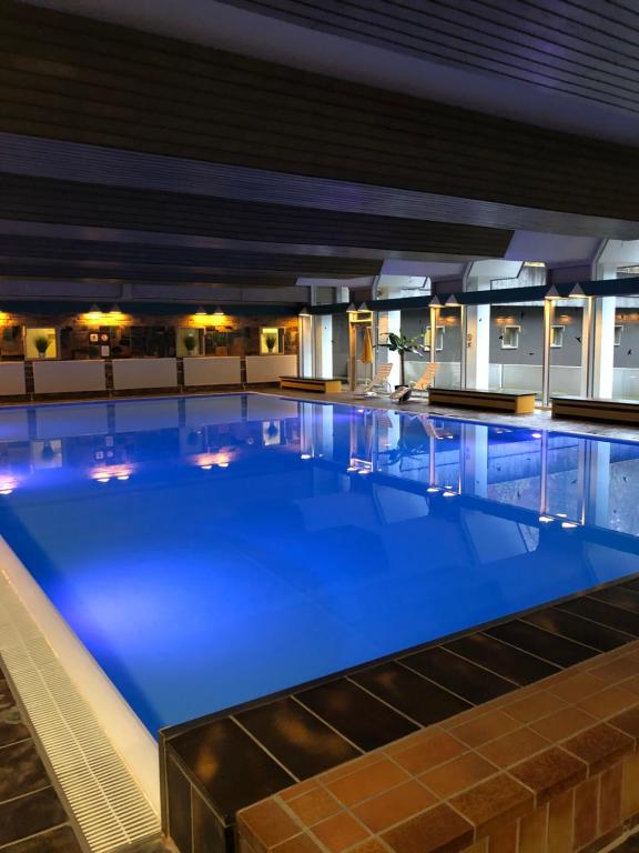 a large swimming pool in a building at night at Mariposa 4 incl Pool & Sauna in Bad Harzburg