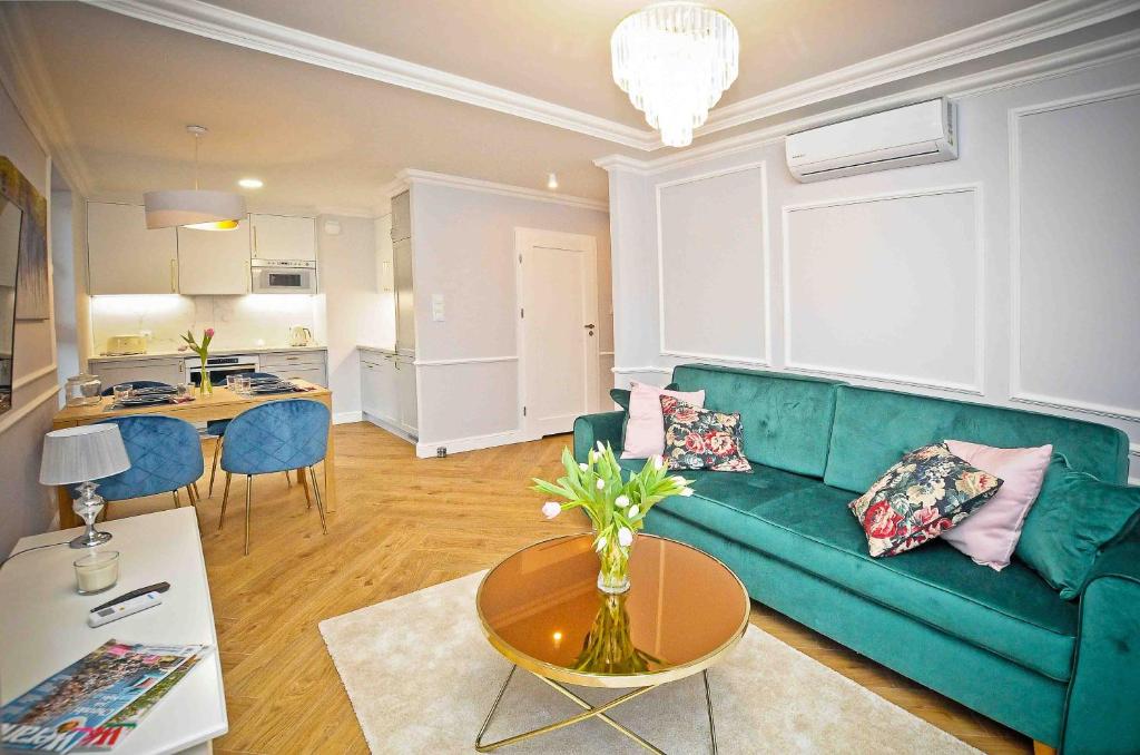 a living room with a green couch and a table at Elegant Apartment Oldtown Marina in Gdańsk