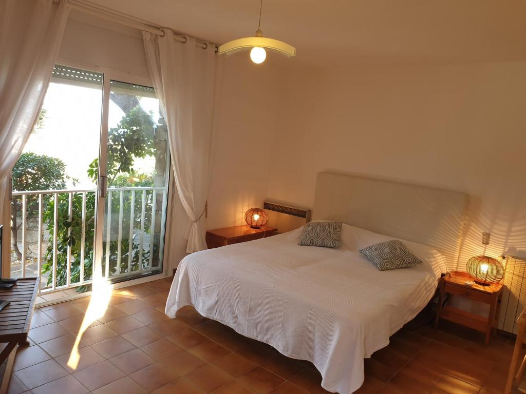 カルヴィにあるVilla U Mulinuのベッドルーム(白いベッド1台、バルコニー付)