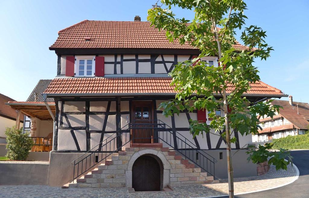 une maison avec un escalier menant à celle-ci dans l'établissement Maison 1775 Ferien im historischen Bauernhaus mit Sauna, Wissembourg, Elsass, à Ingolsheim