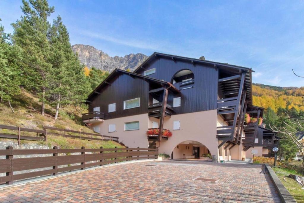 a large building with a fence next to a road at Residence La Contea in Bormio