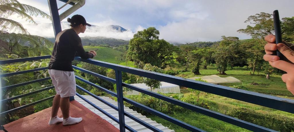 a man standing on a balcony looking at a mountain at Casa Volcano Panoramic View in Vara Blanca