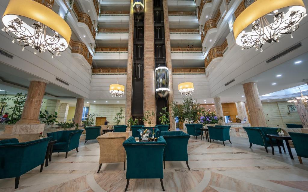 eine große Lobby mit Tischen, Stühlen und Kronleuchtern in der Unterkunft Marhaba Royal Salem - Family Only in Sousse