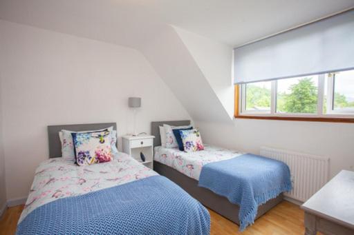 a bedroom with two beds and a window at Fab-u-Luss in Luss