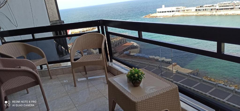 a balcony with chairs and a table and the ocean at شقةفاخرةبجليم على البحر مباشرة in Alexandria