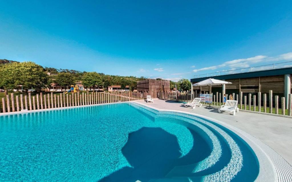 a large swimming pool with blue water at Dives-sur-Mer le Conquérant in Dives-sur-Mer