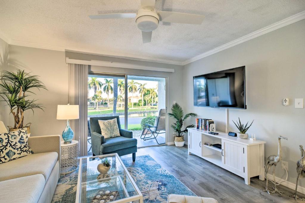 a living room with a couch and a tv at St Pete Condo with Patio and Pool about 2 Mi to Beach in St Petersburg