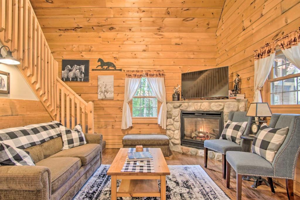 a living room with a fireplace in a log cabin at Rustic Rothbury Cabin with Resort Amenity Access! in Rothbury