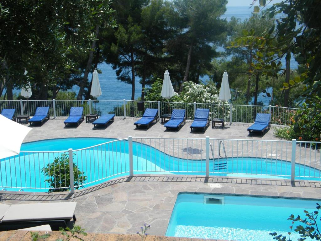 a pool with a lot of chairs and umbrellas at Hotel Villa Delle Meraviglie in Maratea