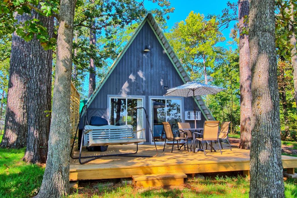 a tiny house in the woods with a table and chairs at Cozy Toledo Bend A-Frame with Waterfront Views! in Burkeville